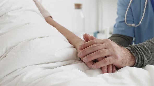 Unrecognizable Male Doctor Checking on Female Patient