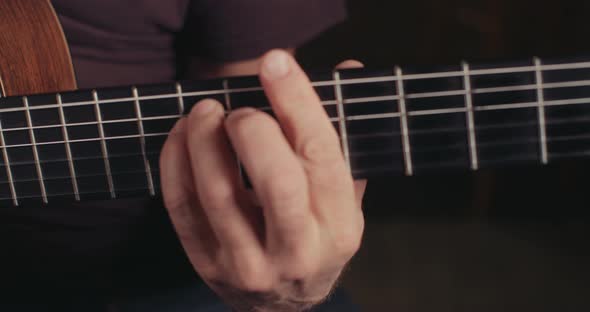 Musician playing acoustic guitar in a recording studio