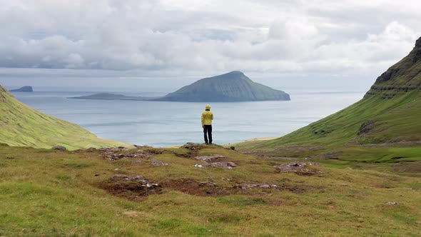 Aerial View of Unrecognizable Man Looking at the Panorama Islands Ocean Green Mountain and Rock