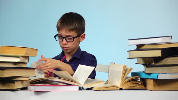 Little Boy Writes in a Notebook, and He Does Not Like. Blue Background. Slow Motion