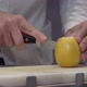 Chef uses a knife to cut the lemon in half. The lemon has seeds inside. - VideoHive Item for Sale