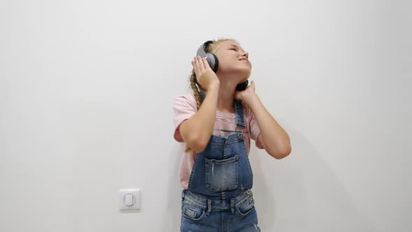 Pretty Young Girl Having Fun Smiling Dancing with Headphones Against White Background