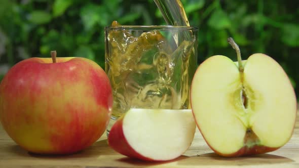 Fresh Apple Juice is Poured in a Glass in Slow Motion