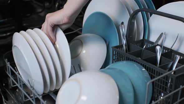 Closeup of Woman Loading Dishwasher in Kitchen