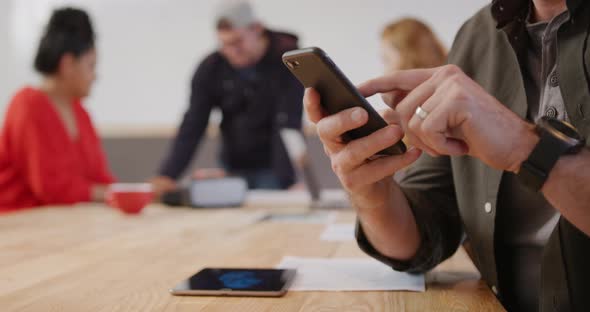 Caucasian man using smartphone in a creative office