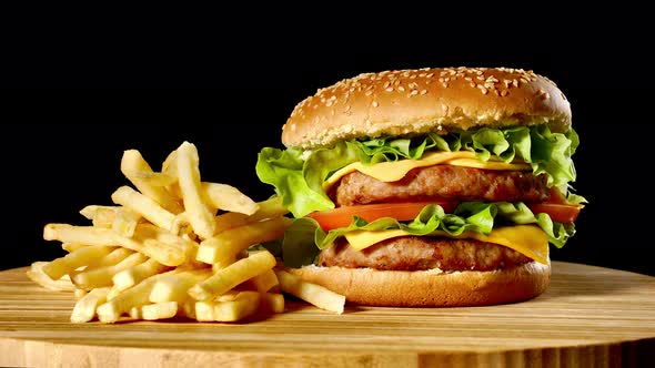 Craft Beef Burger and French Fries on Wooden Table Isolated on Black Background.