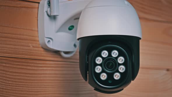 Security Camera Surveillance Rotates on Wooden Background