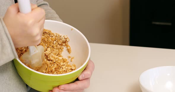 Woman mixing ingredients to bowl for baking