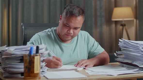Close Up Of Fat Asian Man Working Hard With Documents At The Office