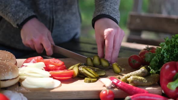 Woman Cuts Cucumbers Making Vegetable Salad Outdoors