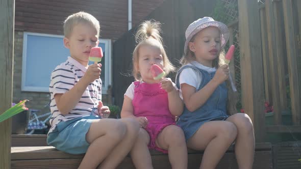 Three Cute Little Children Enjoys Delicious Ice Cream Cone