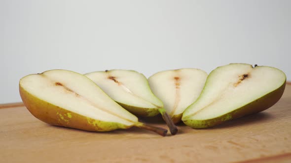 Ripe conference pears cut in half on a wooden cutting board 