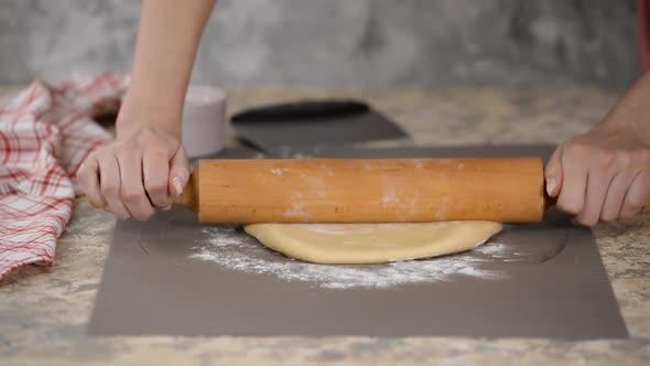 Hands Rolling Out Dough with a Rolling Pin.