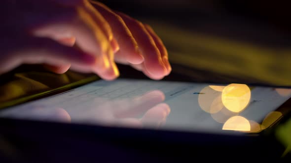 Close up shot of female hand using tablet touching and typing on screen.