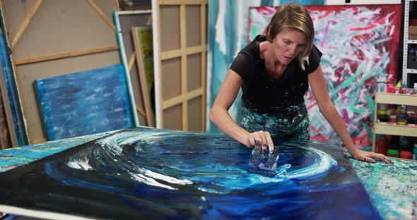 Senior woman painting inside her studio at home