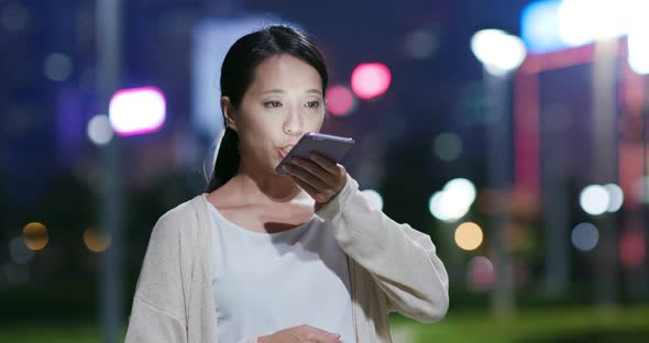 Woman work on mobile phone in city at night