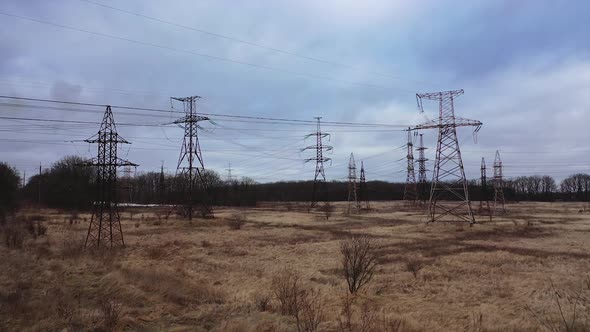 High voltage electric towers on field. Transmission power lines. High voltage power line insulators.