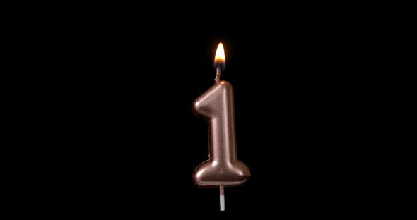 Realistic full-sized single birthday candlelight one 1 first number isolated on black background.