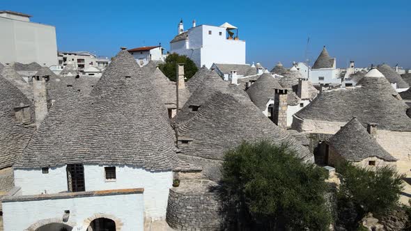 Aerial drone close shot of trullis, small houses, whitewashed stone huts with conical roof. Alberobe