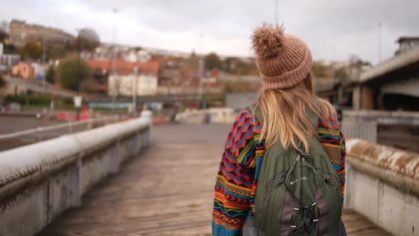 lady in colourful clothing crossing a bridge in Bristol Uk.