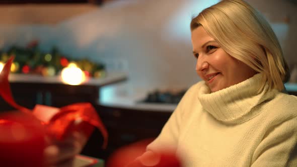 Excited Surprised Woman Receiving Valentine's Gift Box From Unrecognizable Man Indoors