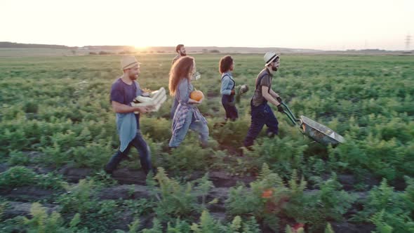 Young Men and Women with Fresh Harvest of Vegetables