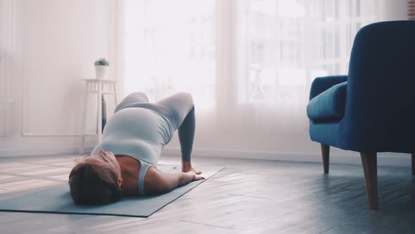 Asian pregnant woman doing yoga exercise at home.