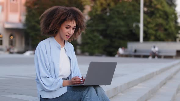 Afro American Woman with Curly Hair African Lady Female Girl Student Freelancer Sitting Outdoors in