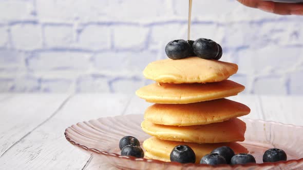 Pouring Maple Syrup on Pancakes