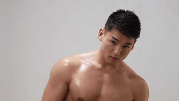 Muscular Asian Man Indoors in Th Studio