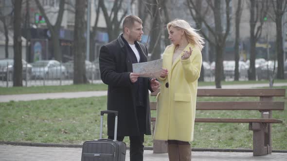 Irritated Caucasian Woman Leaving Elegant Man with Map and Suitcase on Alley Alone