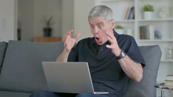 Shocked Middle Aged Businessman Having Loss on Laptop on Sofa