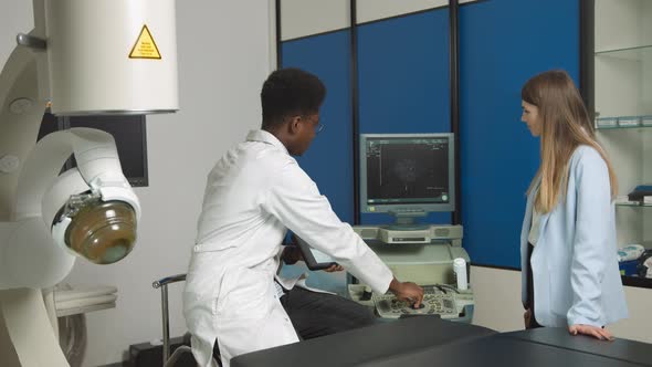 African American Family Medical Doctor in Modern Clinic Holding Tablet Pc and