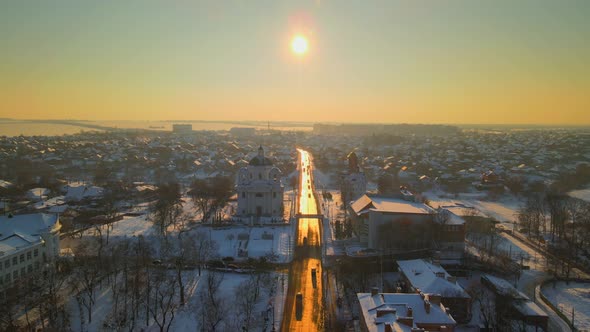 Drone Fly Above Road at Snow Covered Small European City in Winter Sunset HDR