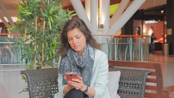 Young Woman Texting in Her Smartphone, Waiting for a Friend and Meeting Her