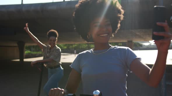 Two mixed race women taking picture in park