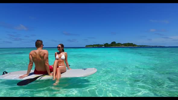 Man and woman tan on exotic resort beach lifestyle by transparent lagoon with white sand background 