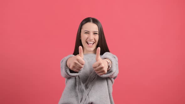 Beautiful Woman Showing Thumbs Up, Isolated on a Red Background.