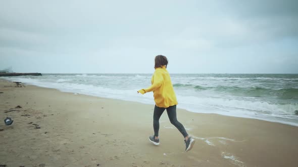 Young Beautiful Female Walking with Siberian Husky Dog on the Beach