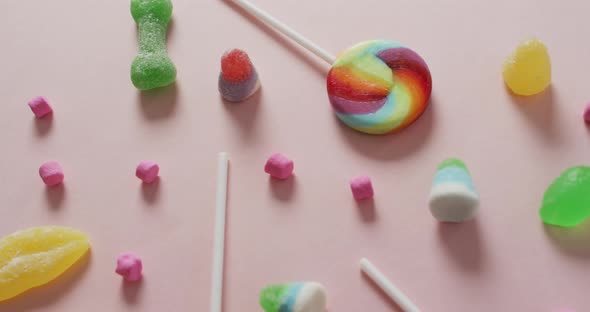 Video of colourful various sweets on pink background