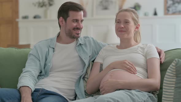 Happy Pregnant Couple Talking with Each Other at Home