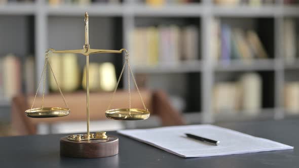 Gold Brass Balance Scale with Document on Lawyer Table