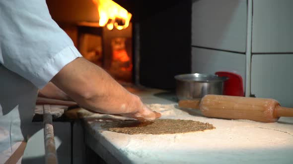 Baker Preparing Pizza In Bakery