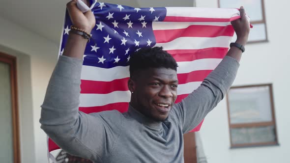 Black Man Waving USA Flag From the Balcony