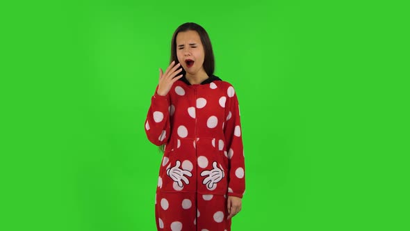 Beautiful Girl in Red Fleece Pajamas Is Yawning, Bedtime Concept. Green Screen