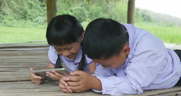 Happy Children Using Tablet In Cottage