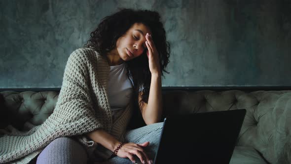 Young African American Woman Feeling Disappointed Reading News Using Laptop at Home