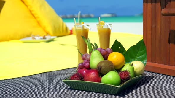 Close up detail of a fruit plate at a picnic on a tropical island beach.