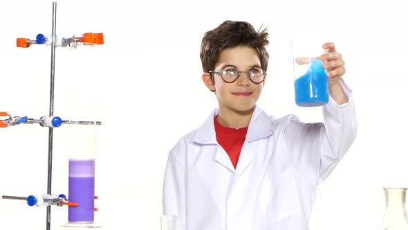 Young Boy Chemist Wearing Uniform, Red Shirt and Round Glasses in Laboratory Making Some Experiment