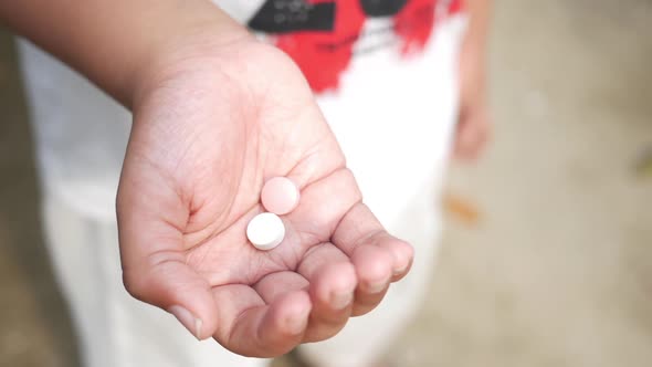 Close Up of Medical Pills on Palm of Child Hand